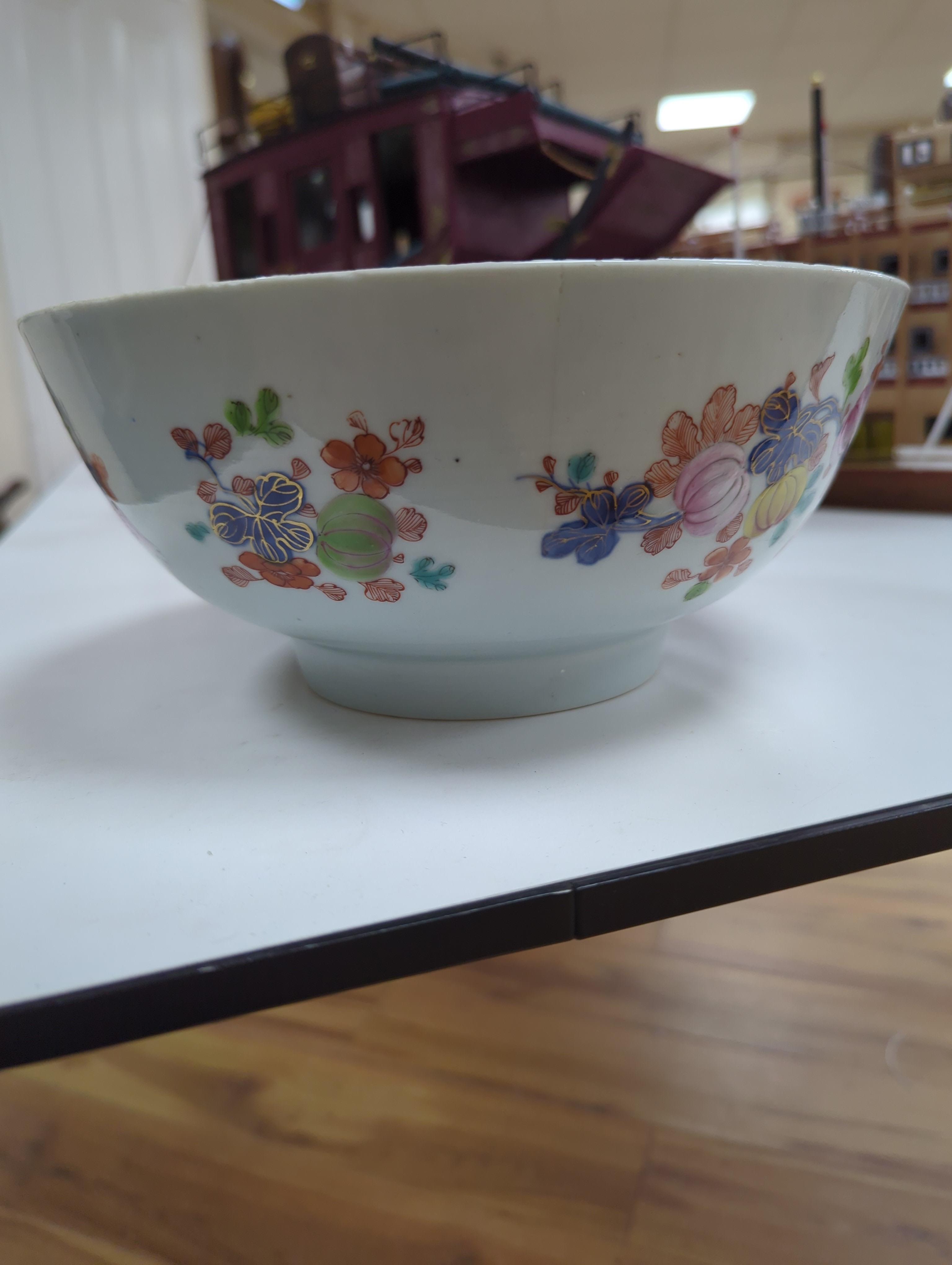 An 18th century Chinese famille rose bowl and a group of five Chinese wucai plates, each decorated with fruit, the bowl 23cm in diameter